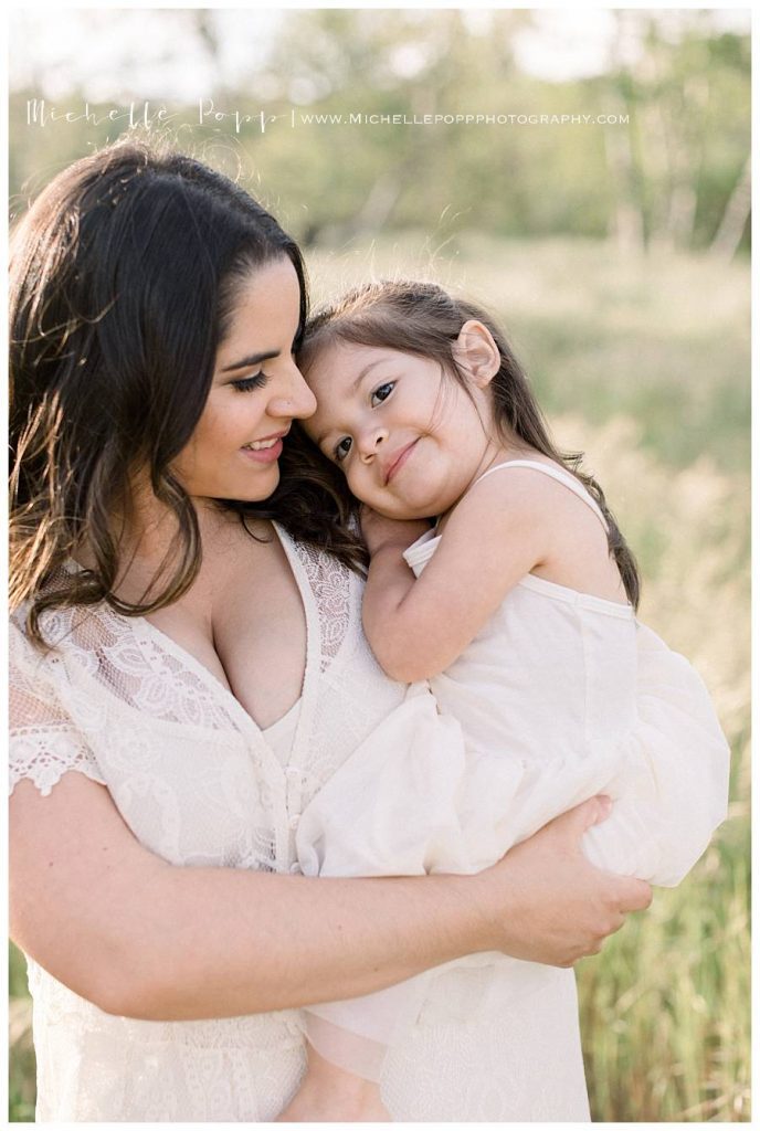 mom holding daughter and smiling