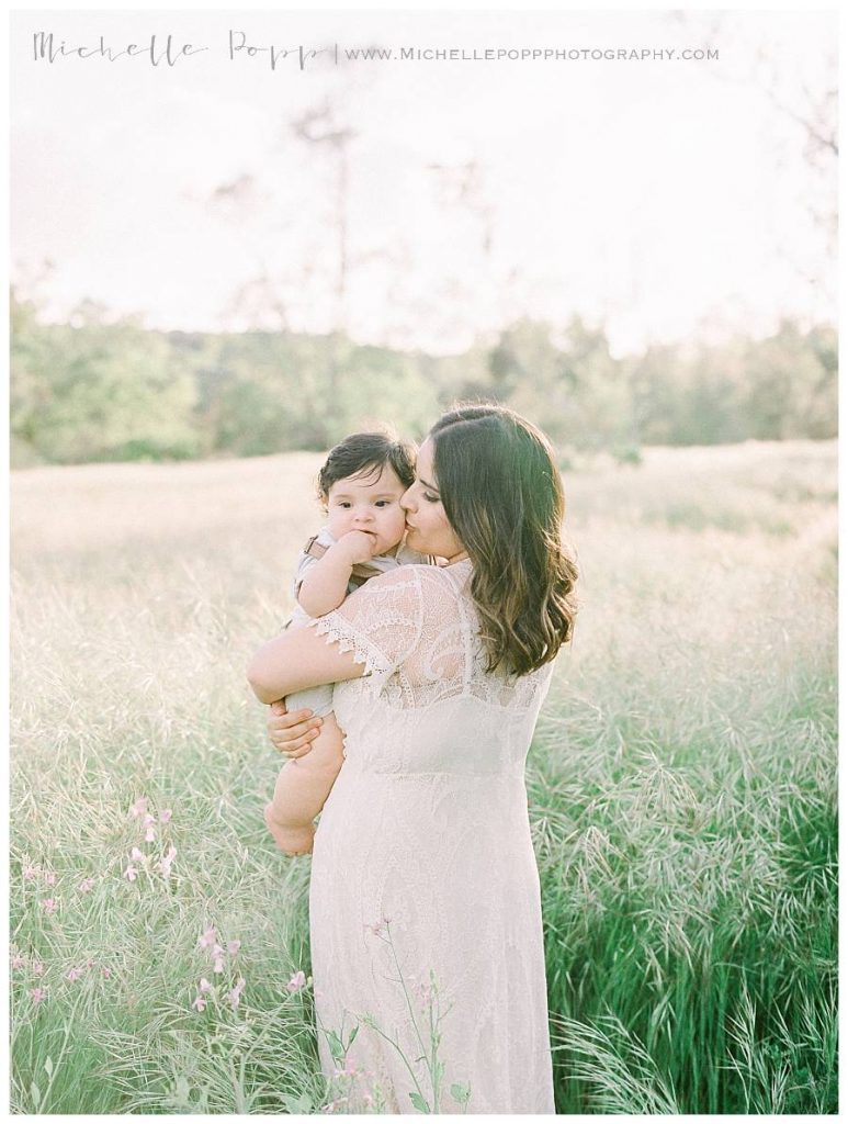 mom holding baby boy in field