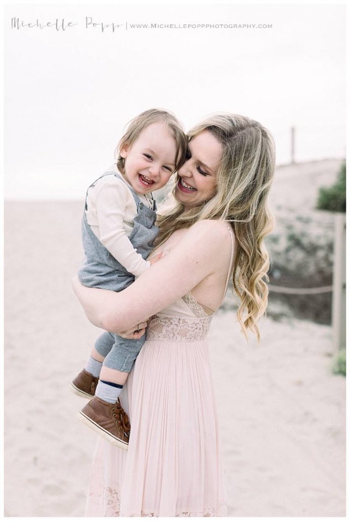 mom holding boy at beach