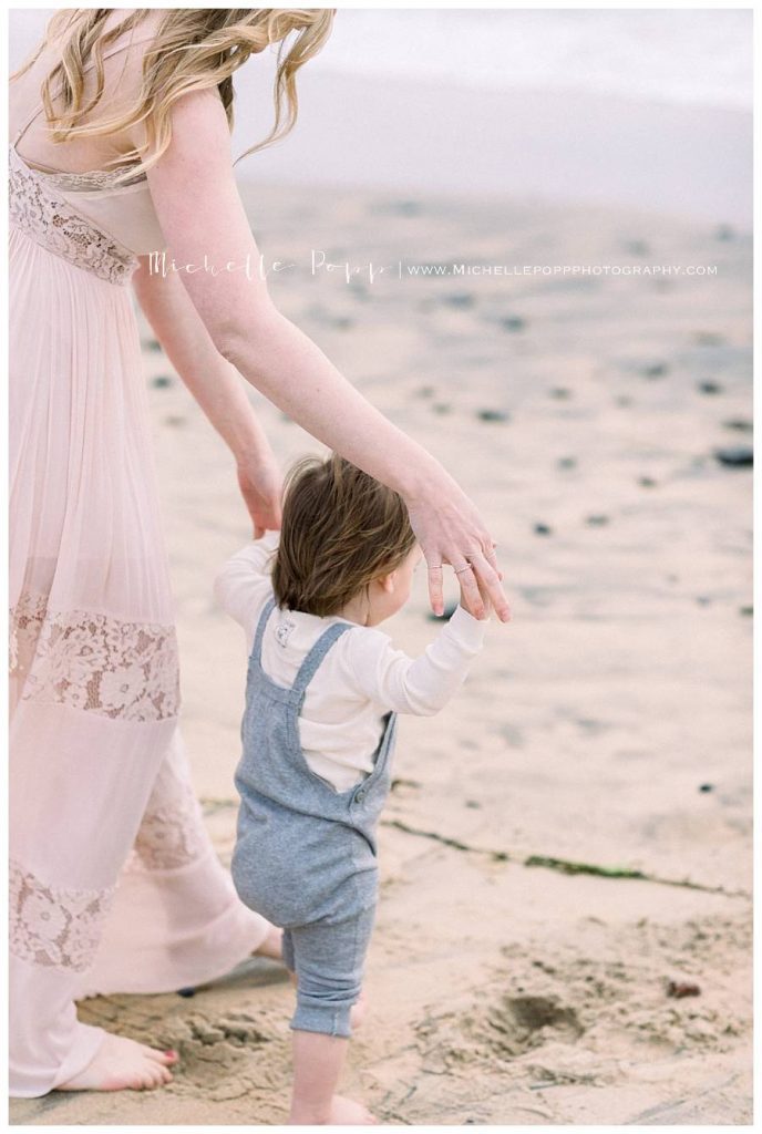 mom holding sons hands and walking