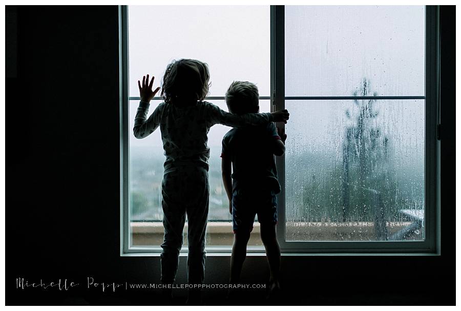 boys standing at the window looking out