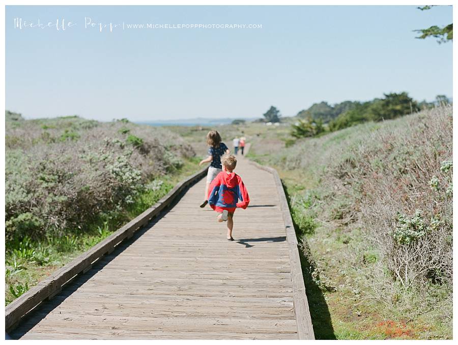 boys running down a boardwalk