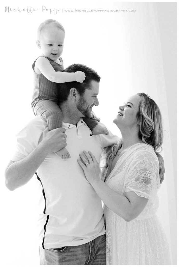 toddler son sitting on dads shoulders