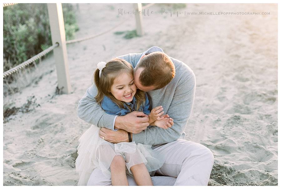 dad kissing daughter on the cheek