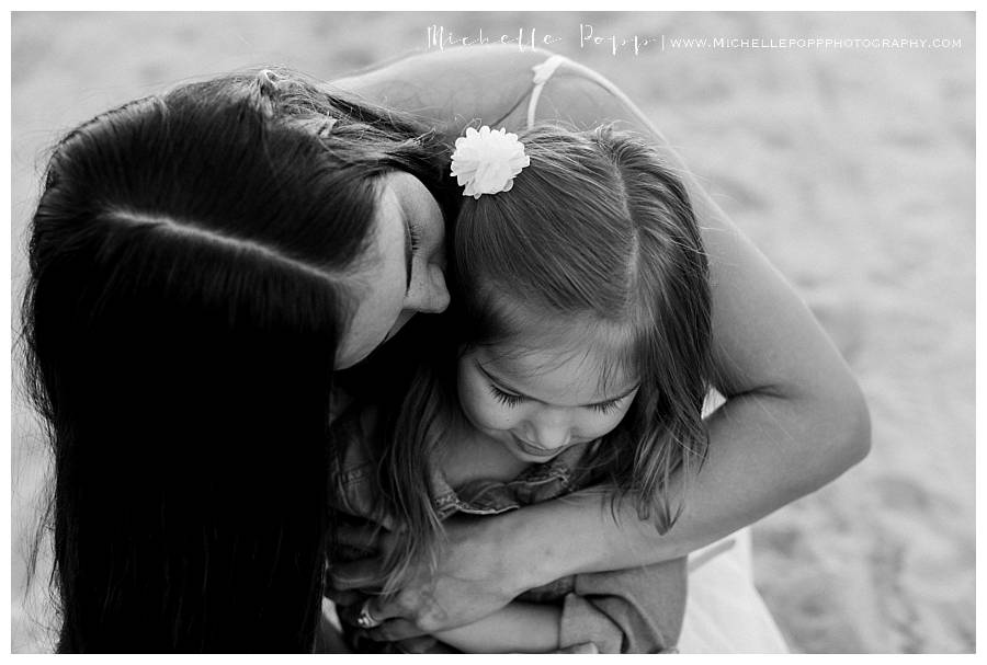 mom kissing daughter on the cheek