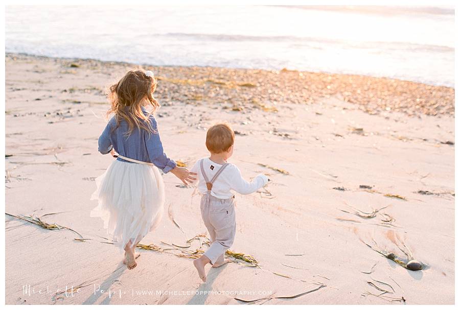 two kids running towards ocean