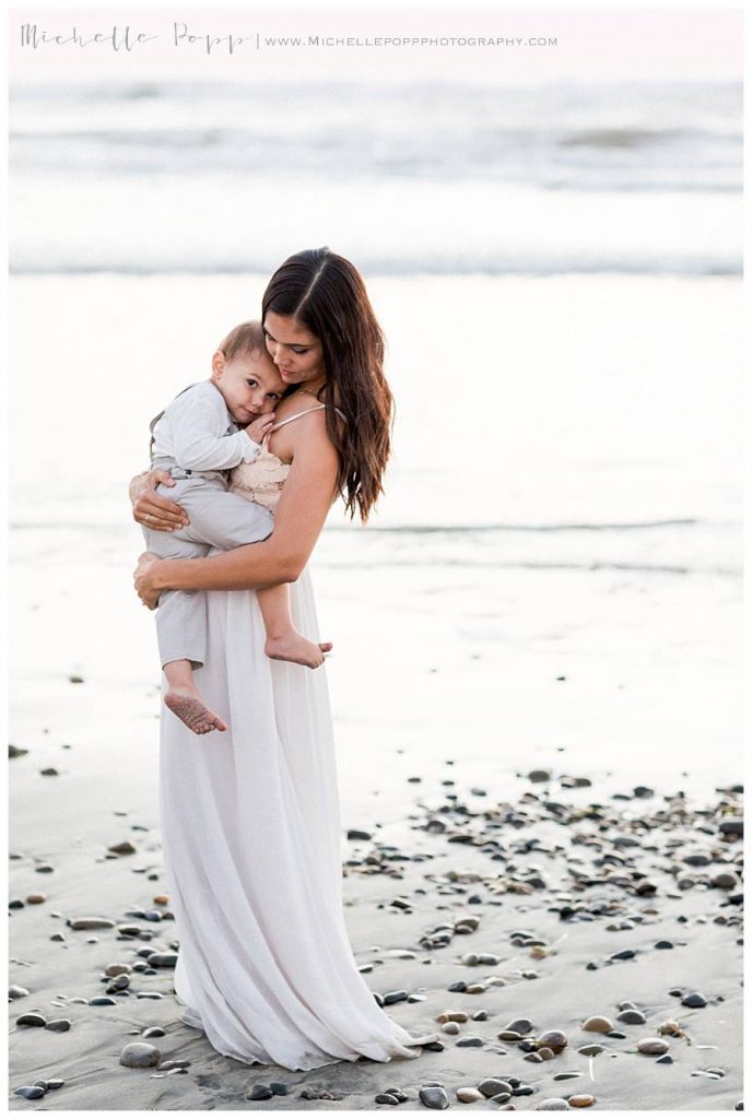 mom holding son by the ocean