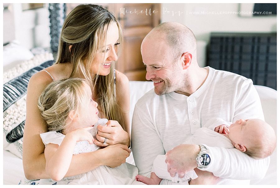 dad smiling at daughter and wife