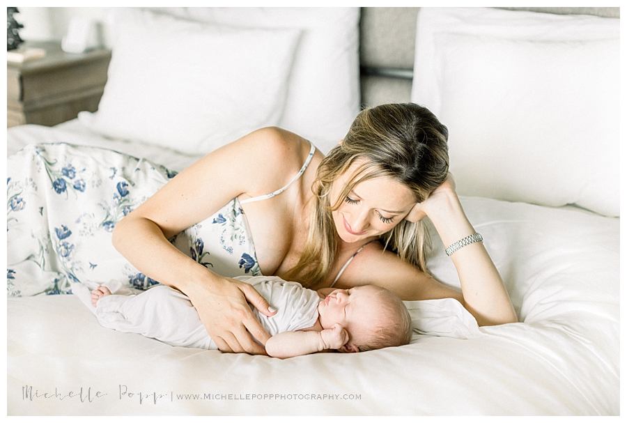 mom lying next to baby in bed