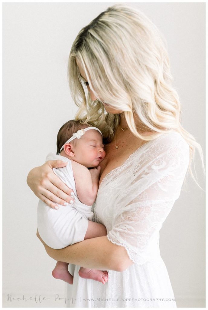 mom holding newborn baby against chest