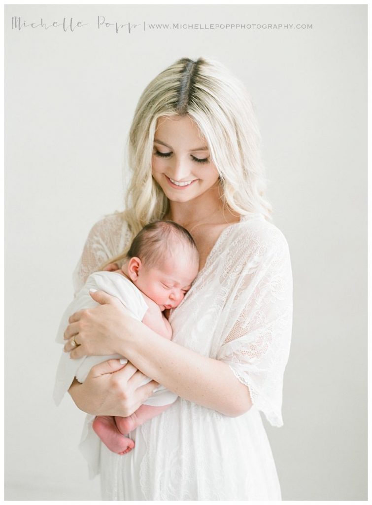 mom holding newborn baby against chest, Intimate newborn photography
