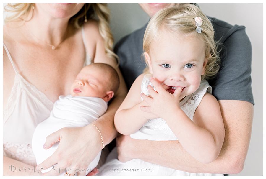 little girl smiling through hands