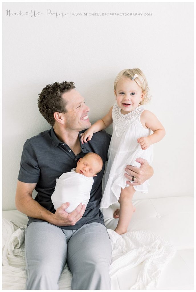 dad holding two kids on lap