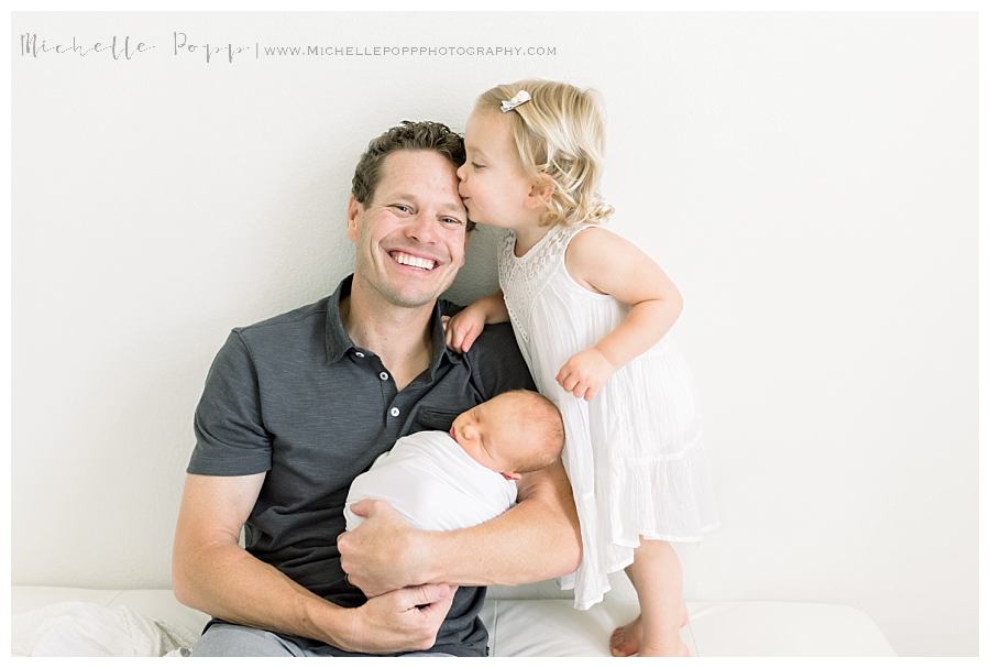 daughter kissing dad on forehead