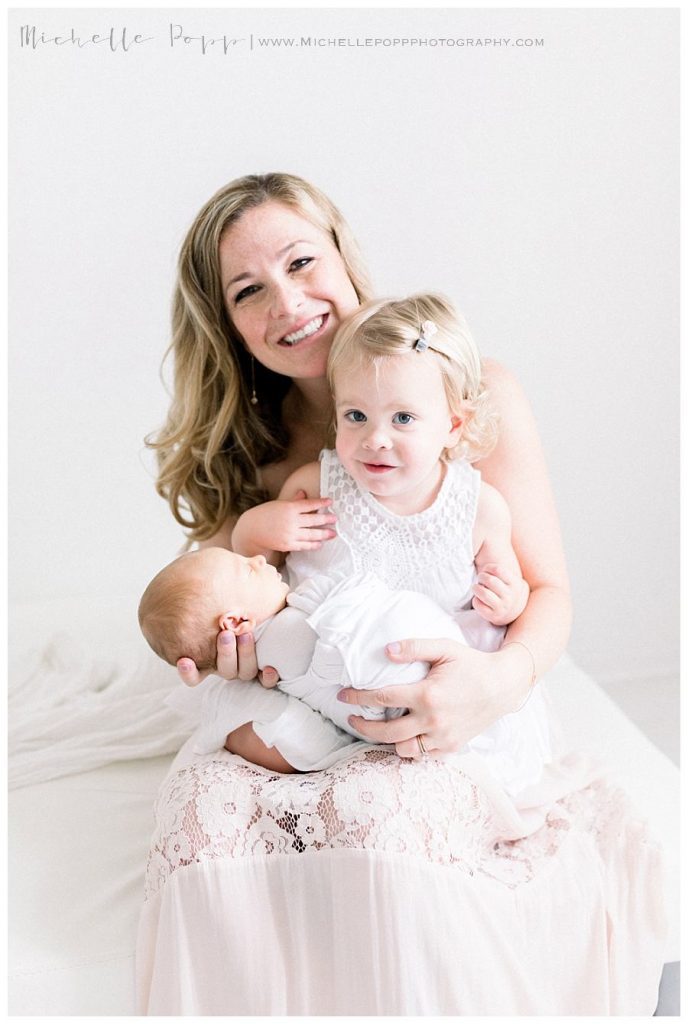 mom holding two kids on lap