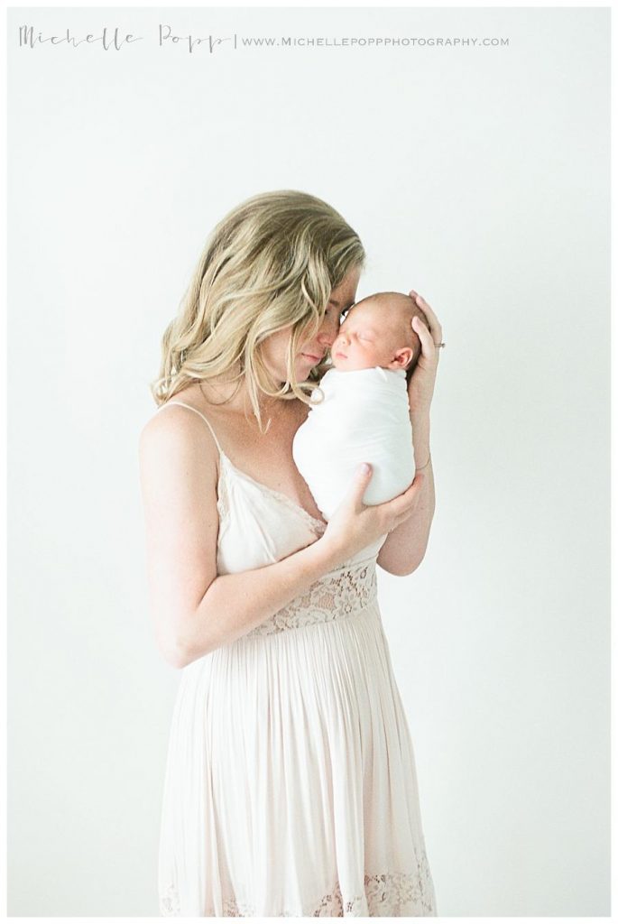 natural newborn photographer mom snuggling newborn baby