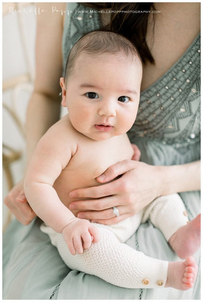 mom holding baby on lap 