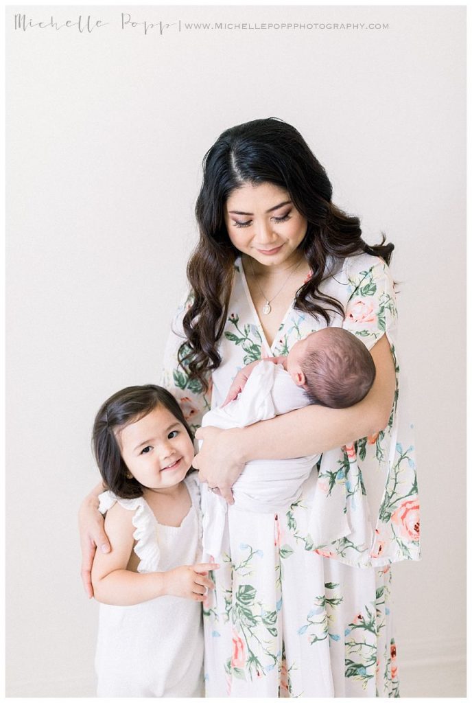 mom and daughter holding newborn baby