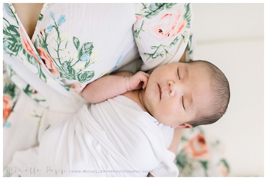 newborn asleep in mom's arms