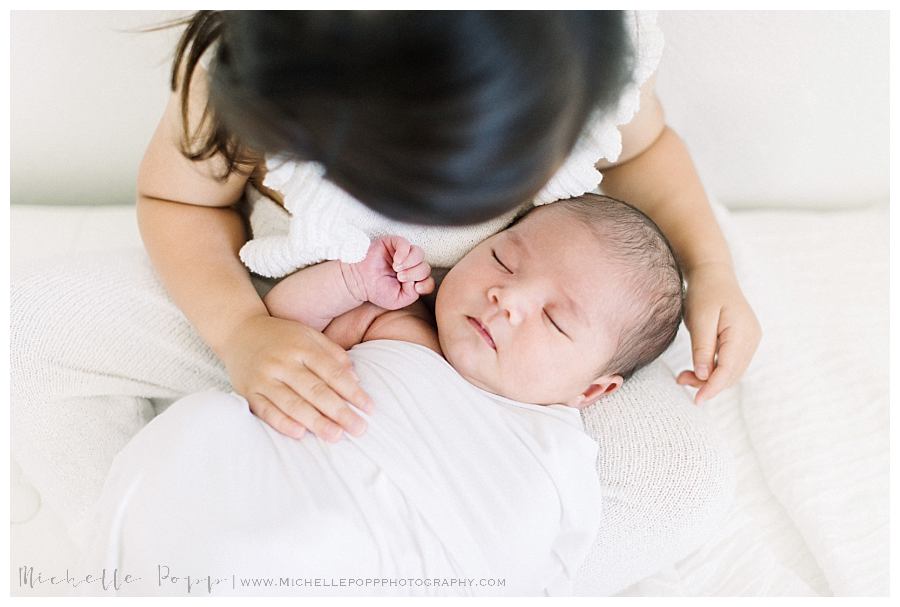 toddler girl holding new baby