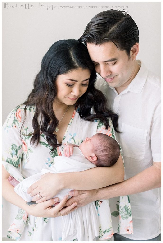 new parents looking down at baby