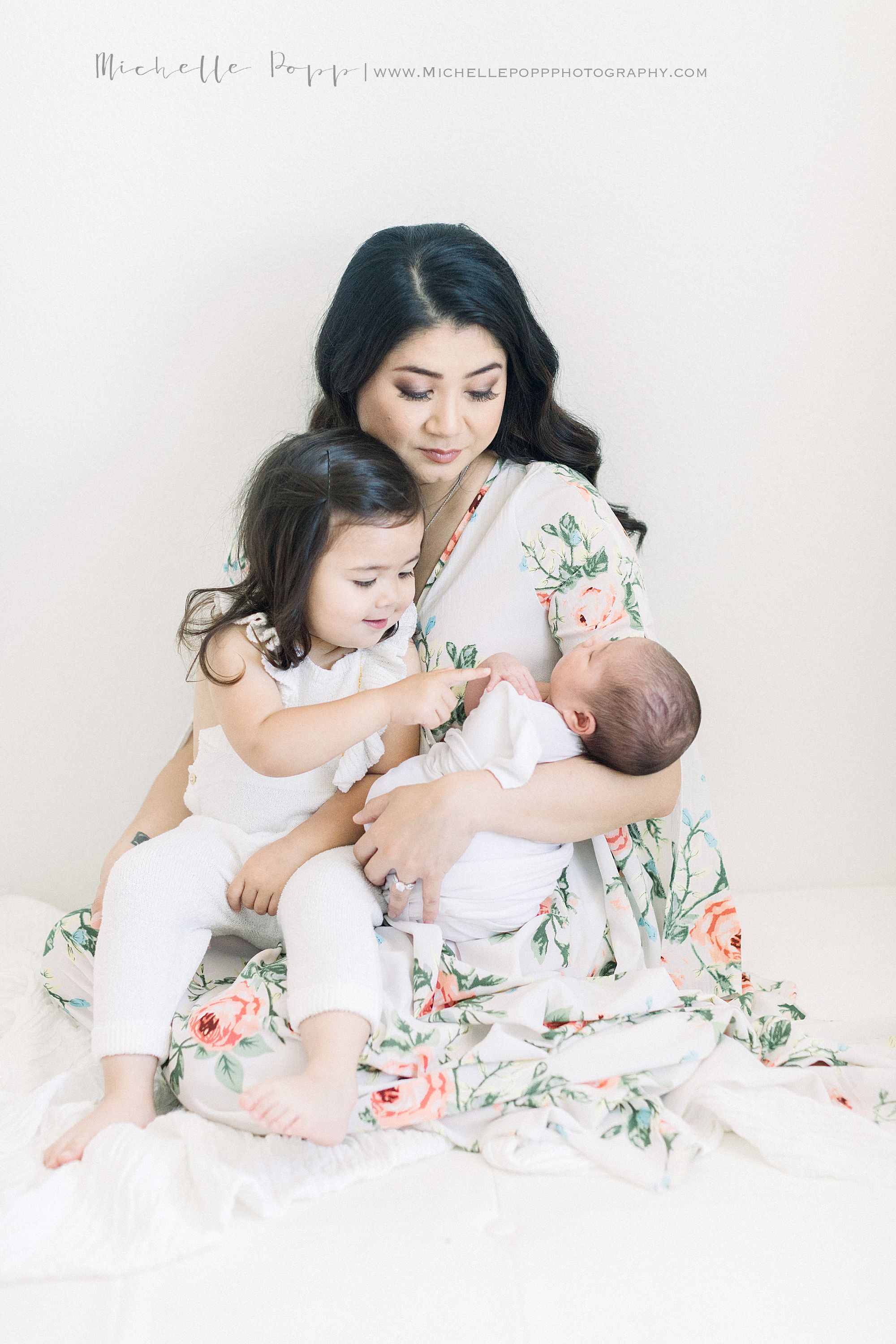 San Diego newborn session with sibling touching baby sister