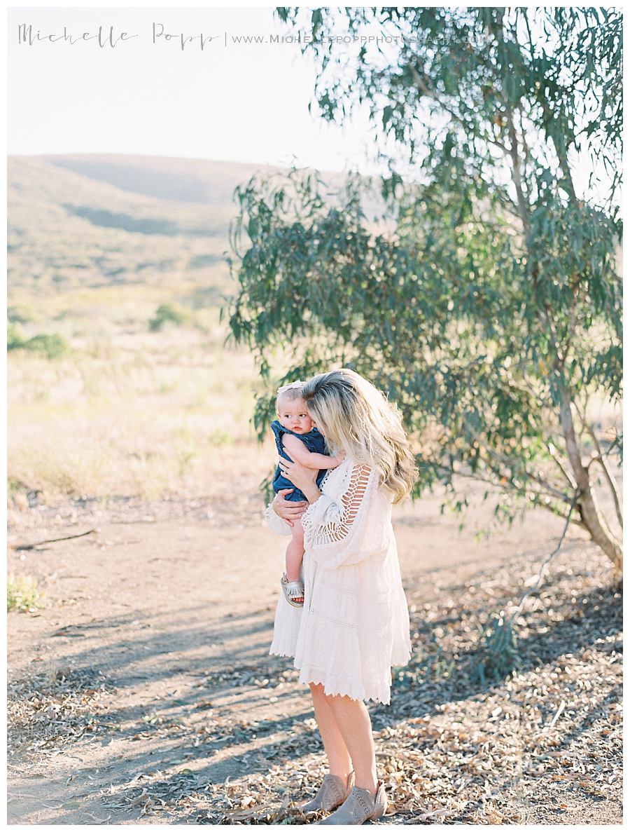 mom in field holding baby girl