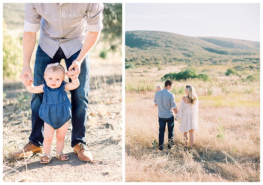 dad holding baby girl standing up in field