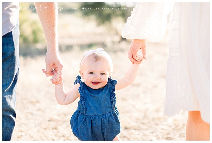 baby girl in blue romper smiling