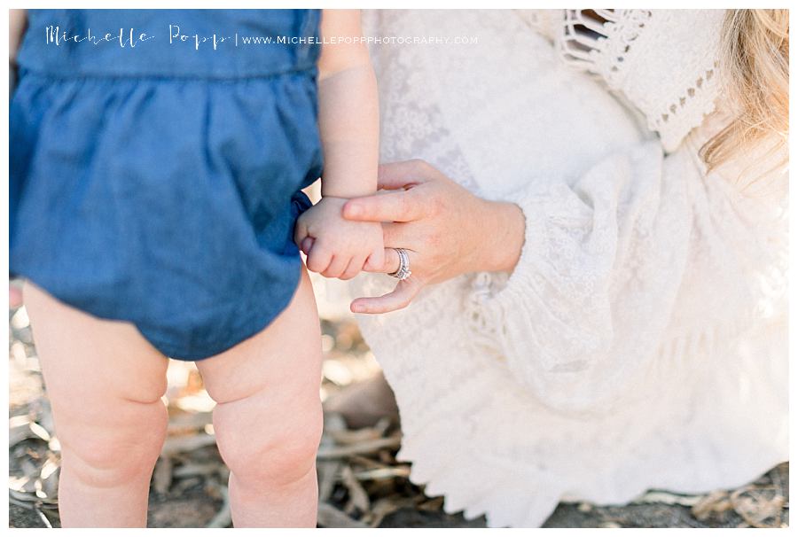 close up of mom and daughter holding hands