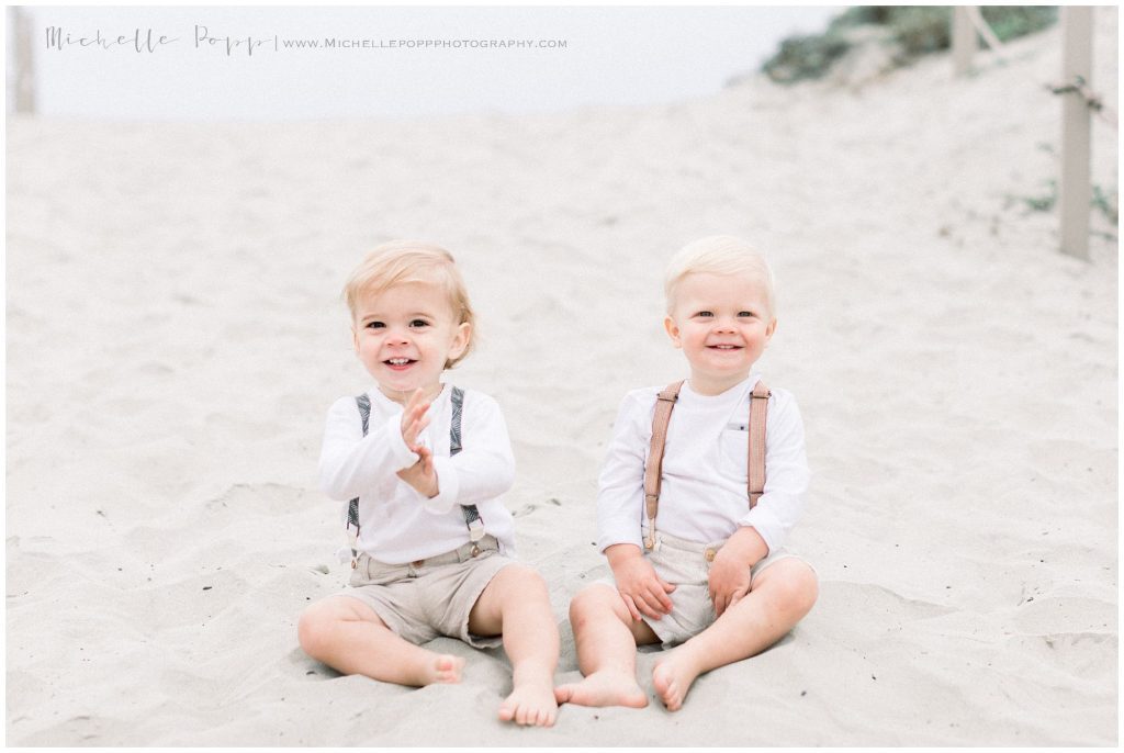 twins sitting on the beach