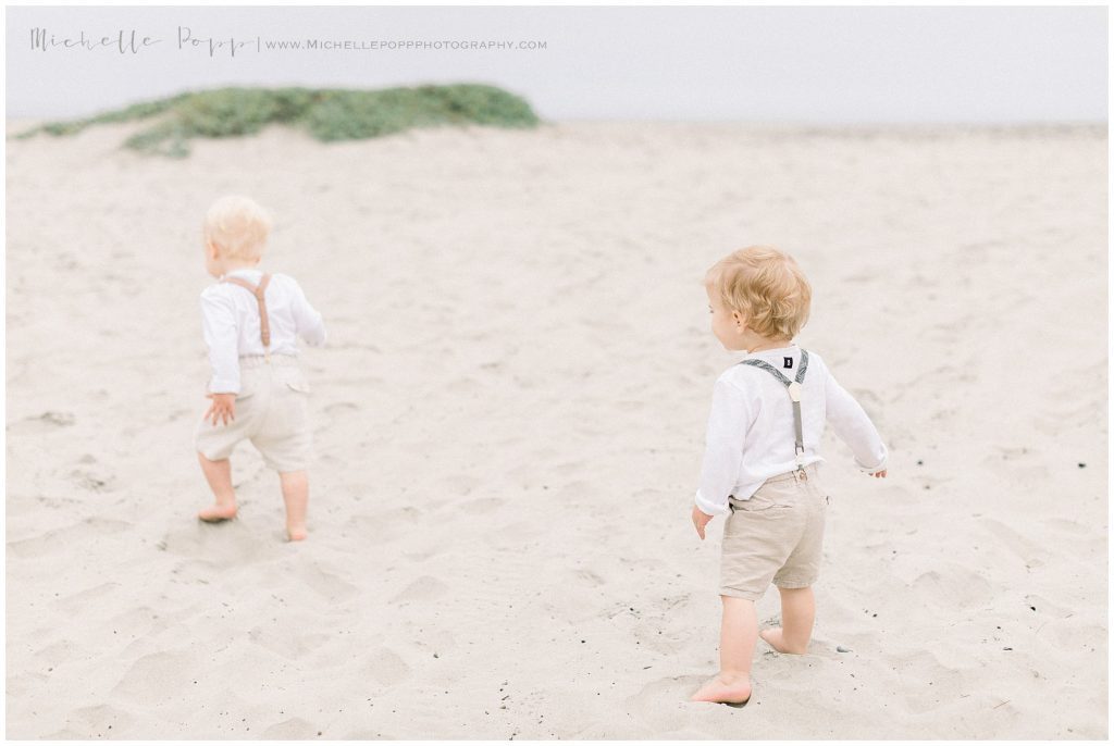 twin boys running on beach
