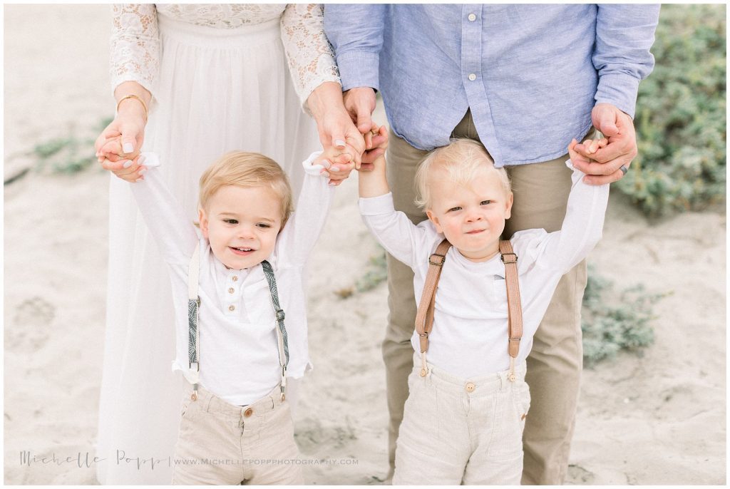 parents holding baby boy's hands