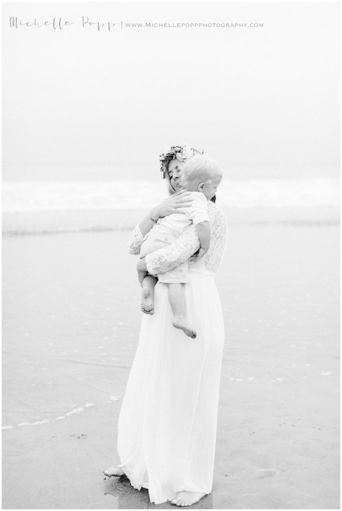 mom holding baby boy on the beach