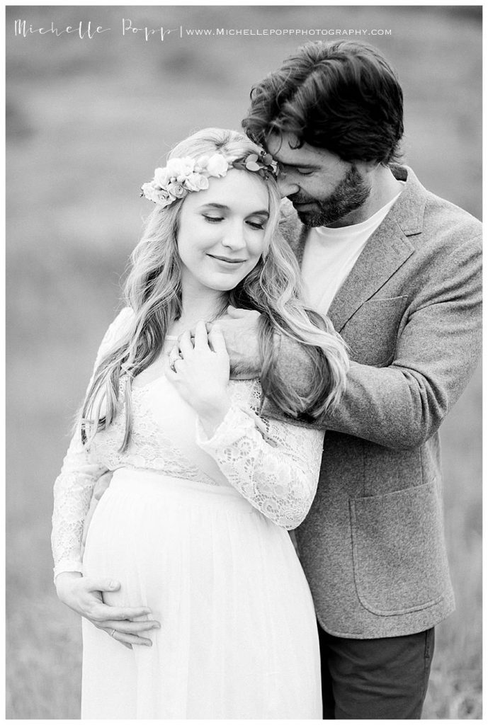 expectant mom with husband in a field black and white