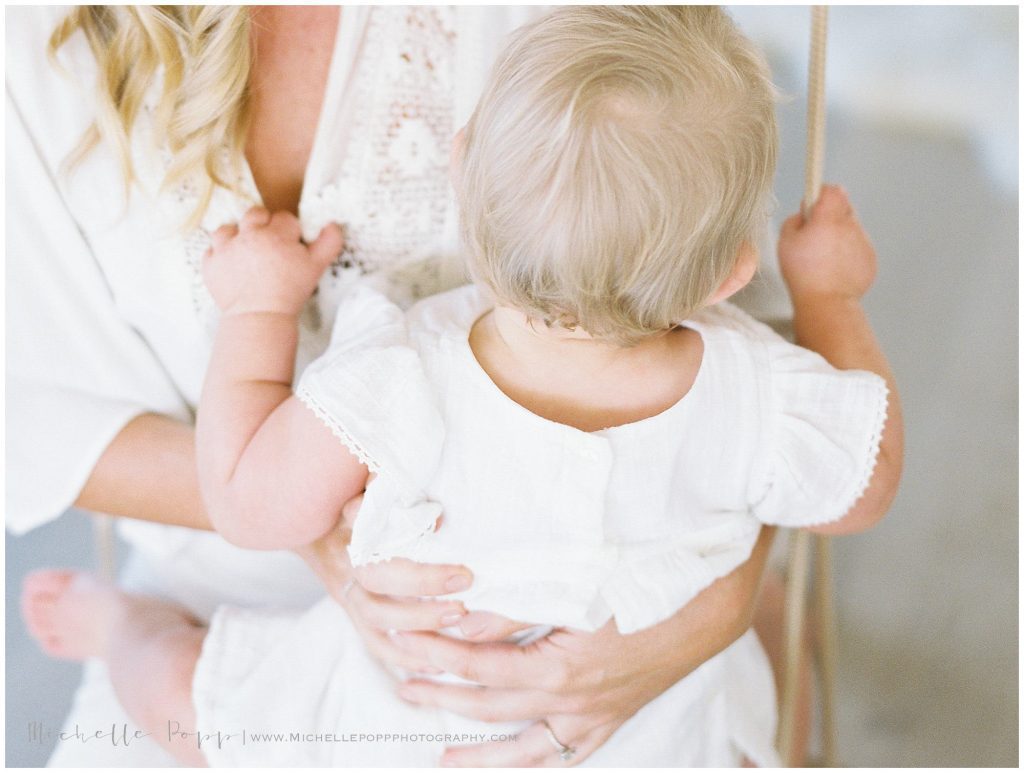 mom rocking baby girl on lap