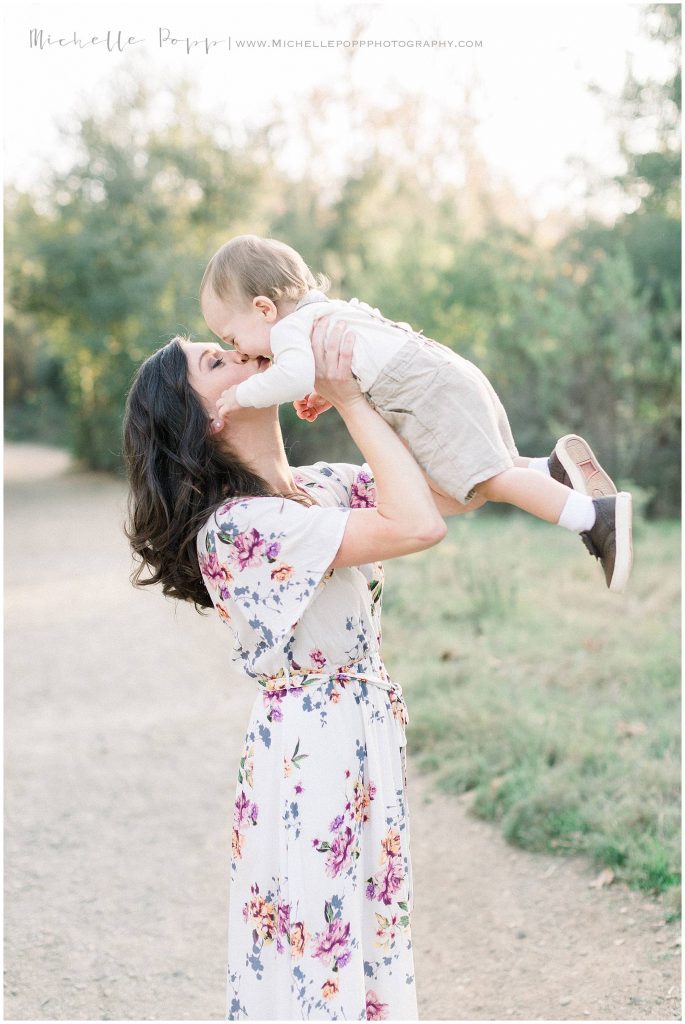 mom lifting little boy in air and kissing his nose. Choosing the Best Location in San Diego for Family Portraits