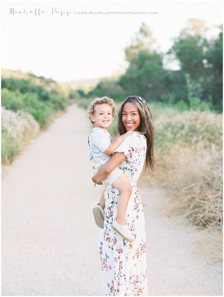 mom holding son in arms in field