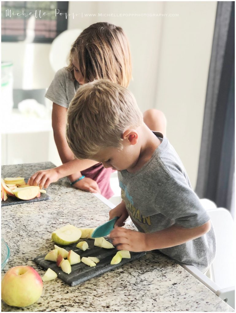 two boys in kitchen slicing apples for pie