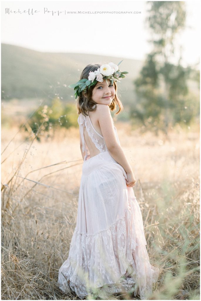 little girl in a flowy dress in a field