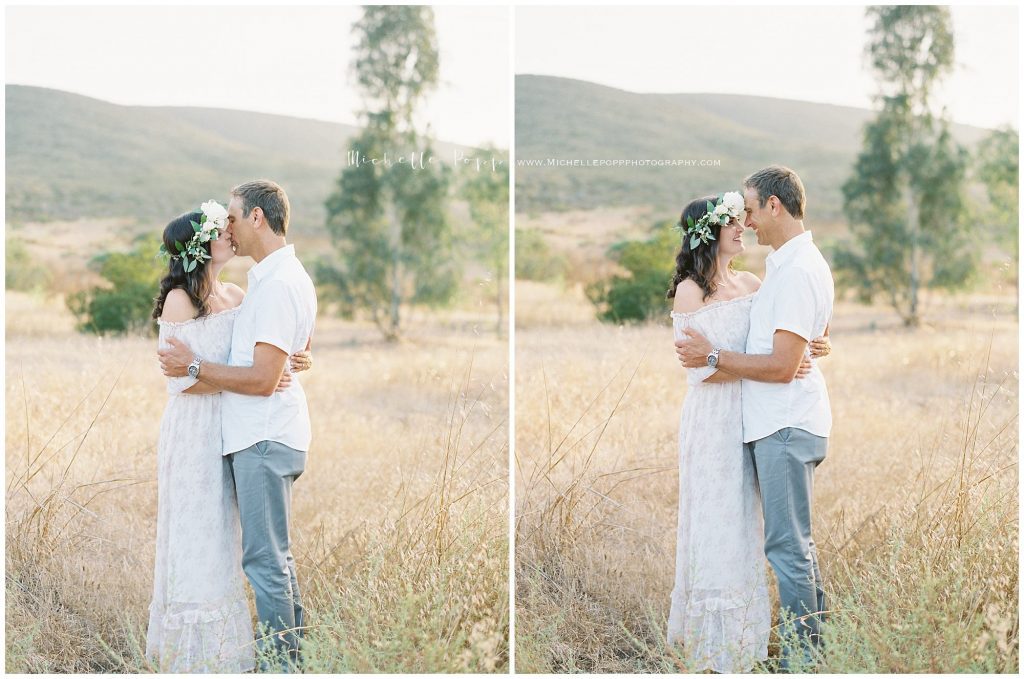 mom and dad standing in a field kissing