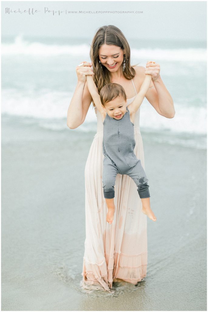 mom lifting boy up by the arms