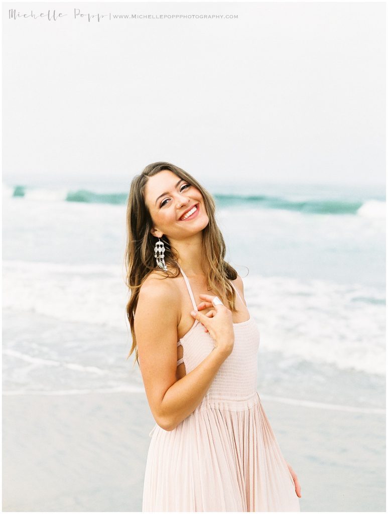 woman in dress smiling standing on beach