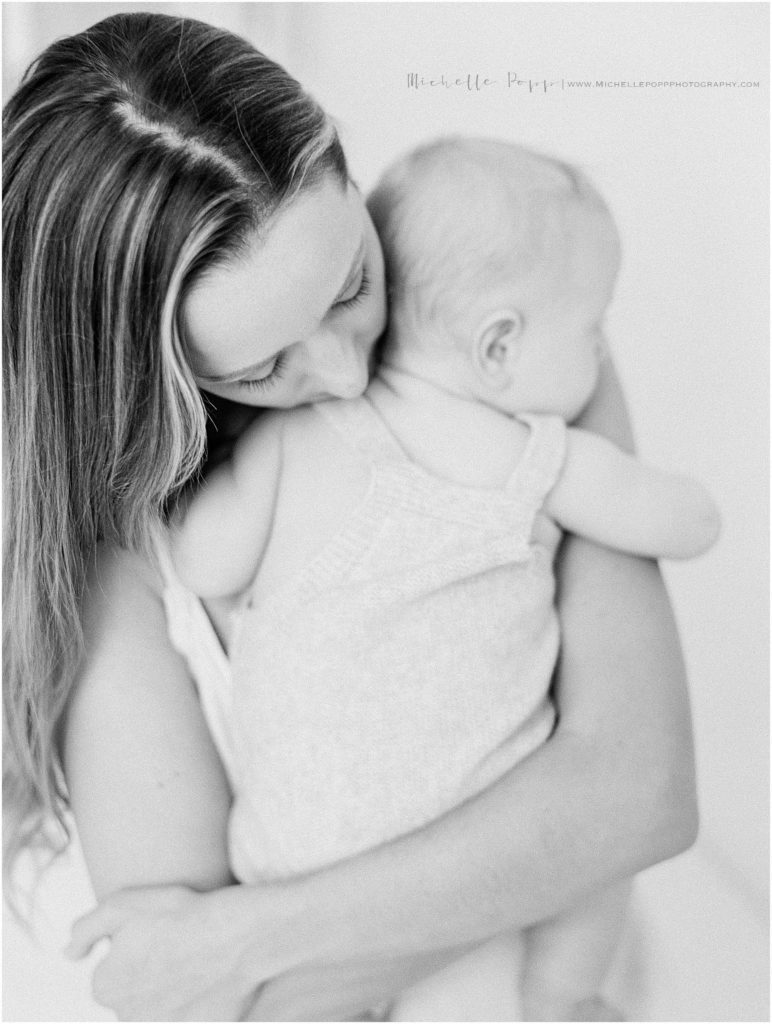 black and white photo of mom and baby snuggling 