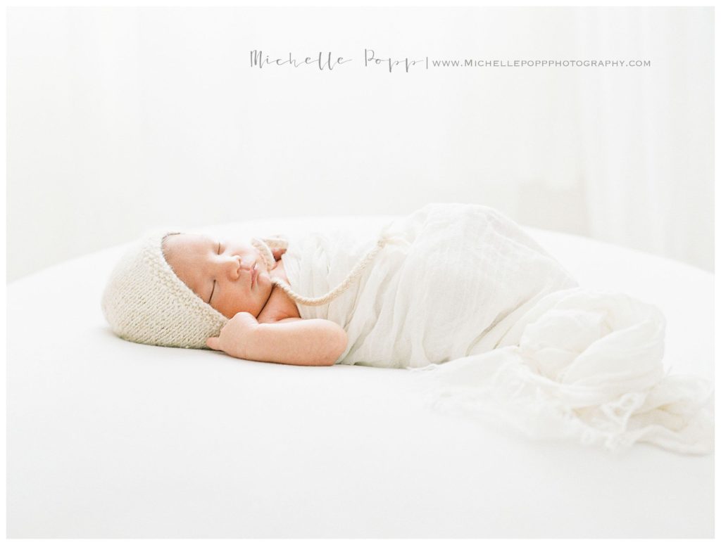 newborn baby in studio with bonnet