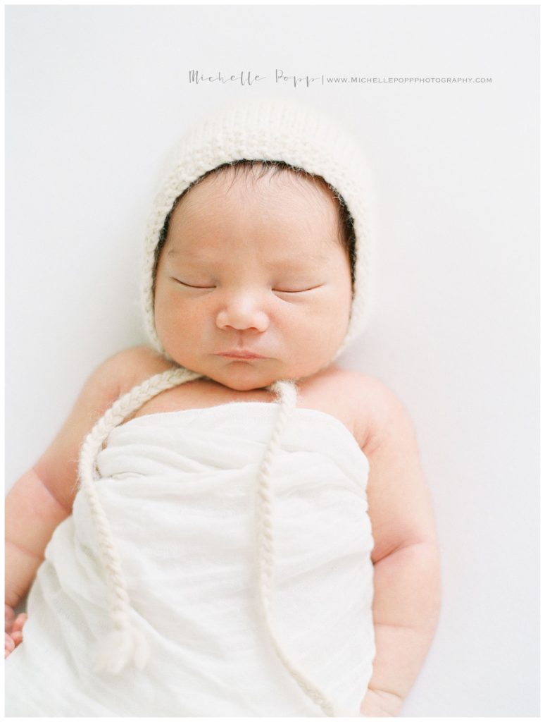 newborn baby with a bonnet