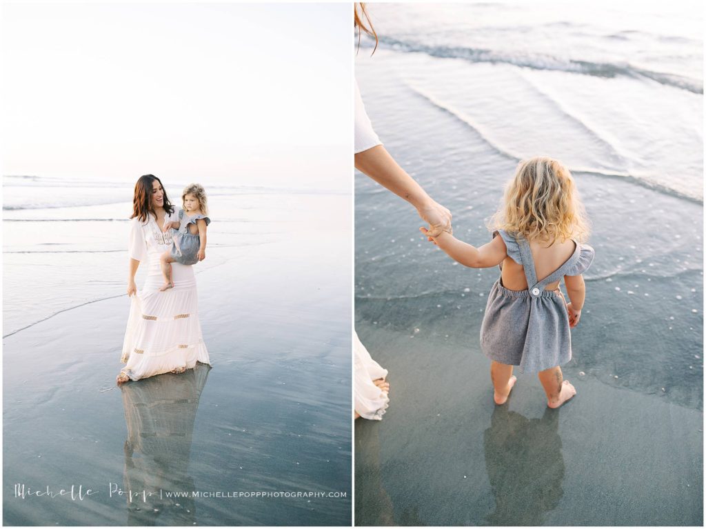 mom holding daughter's hand walking into the ocean 