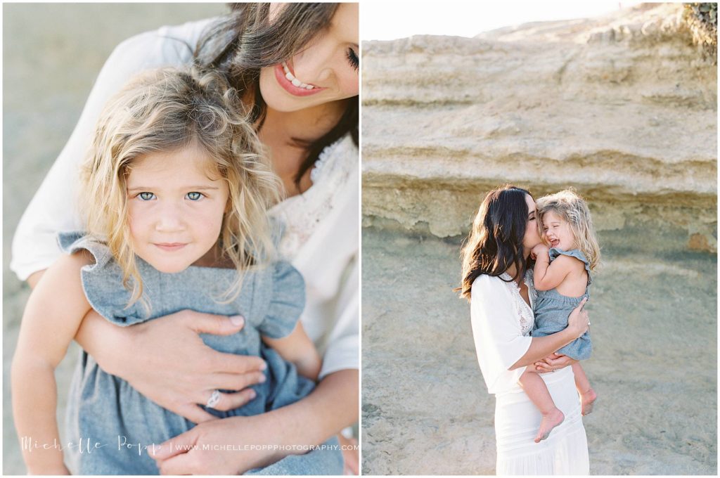 Mom snuggling daughter in front of cliff