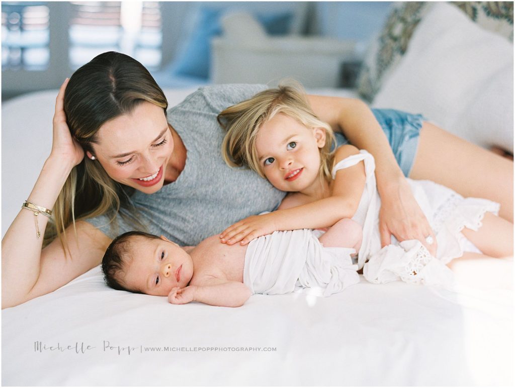 mom laying on bed with babies